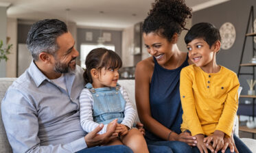 Adoptive mixed race family smiling at each other